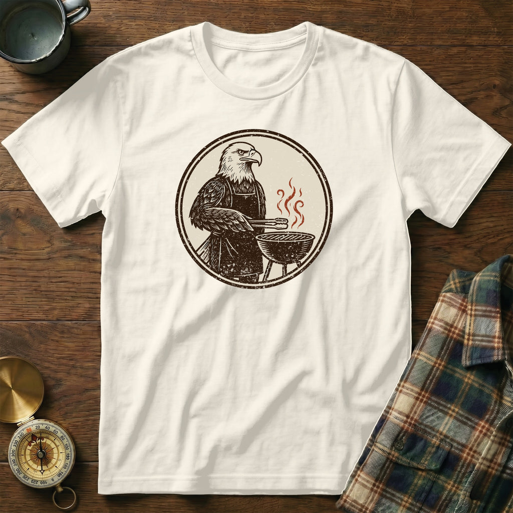 Cream t-shirt with graphic of eagle grilling on a barbecue.