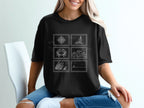 Black t-shirt with postage stamp designs of a compass, crab, waves, grass, and sailboat.
