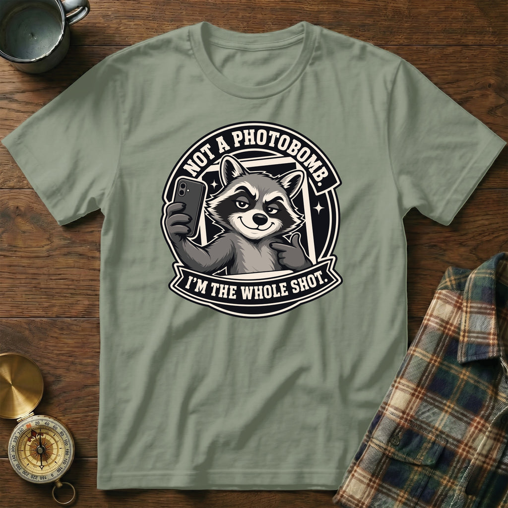 Green t-shirt with a graphic of a raccoon taking a selfie, reading "NOT A PHOTOBOMB. I'M THE WHOLE SHOT."