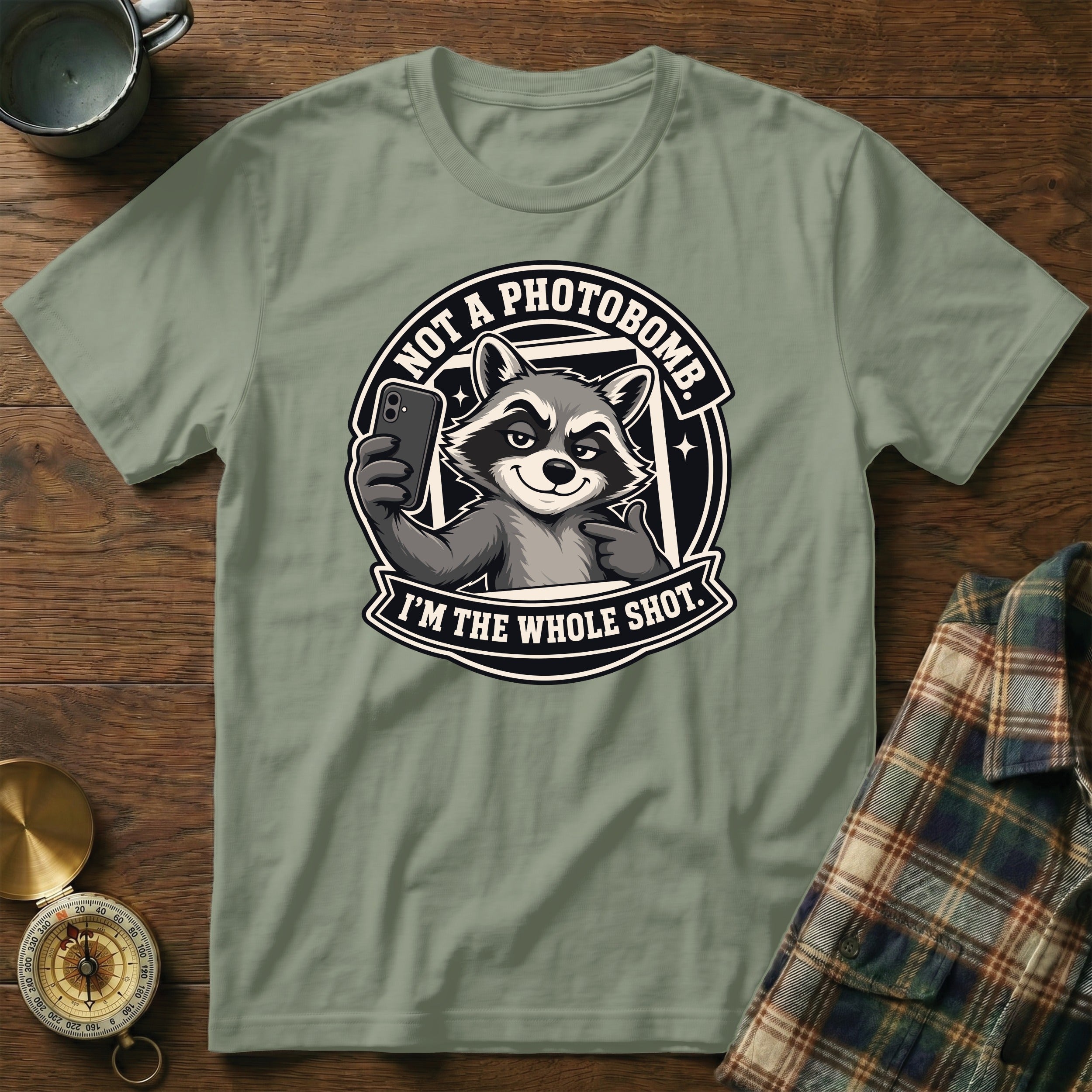 Green t-shirt with a graphic of a raccoon taking a selfie, reading "NOT A PHOTOBOMB. I'M THE WHOLE SHOT."
