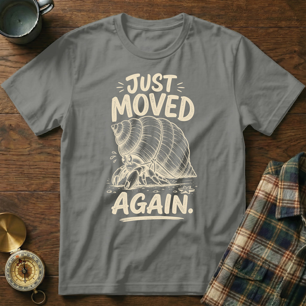 Hermit crab graphic with text "JUST MOVED AGAIN" on a gray t-shirt.