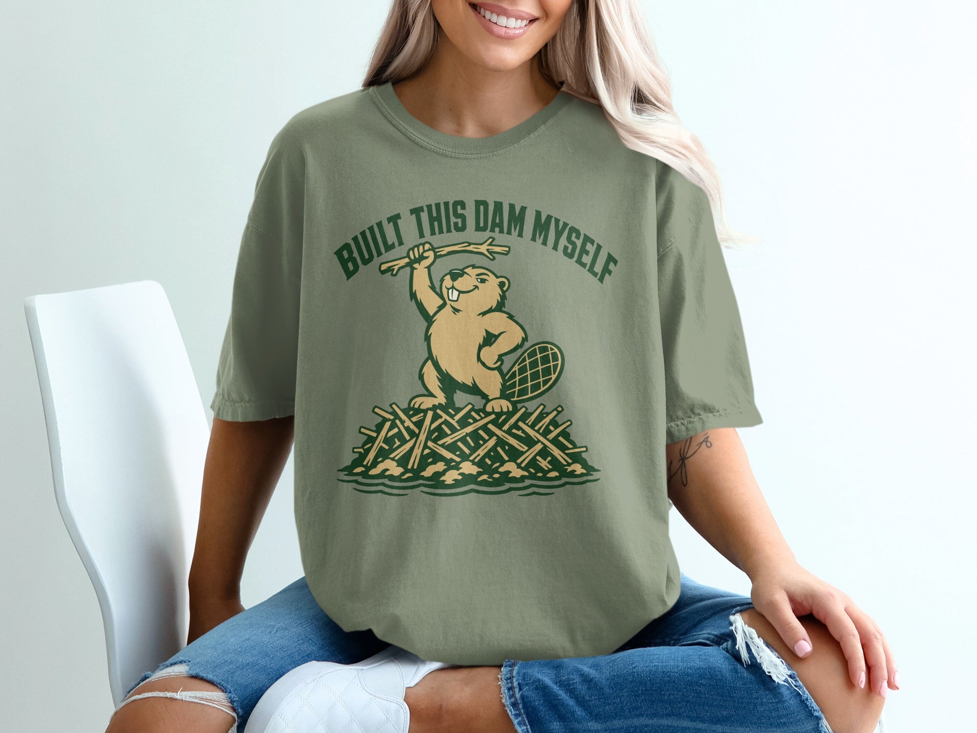 Green t-shirt with text "BUILT THIS DAM MYSELF" and a cartoon beaver on sticks.