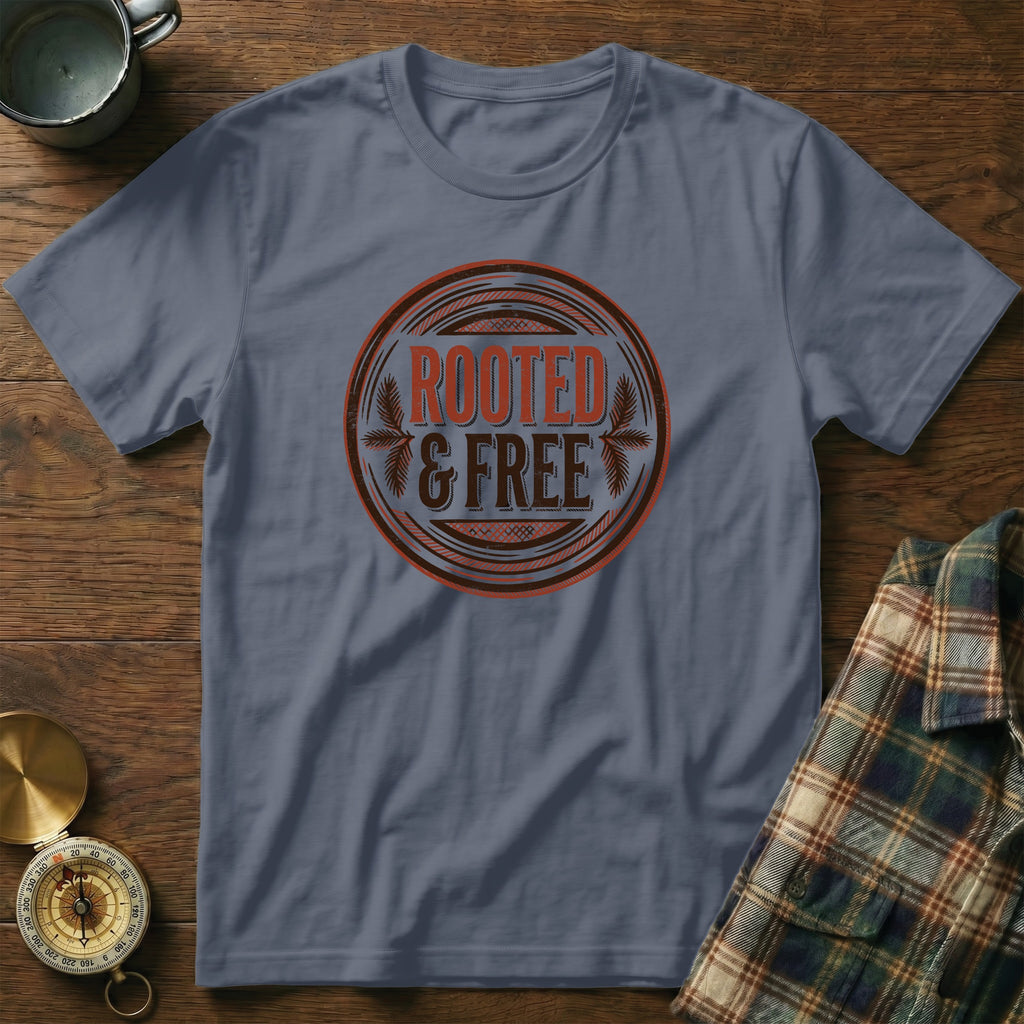 Blue t-shirt with circular "Rooted & Free" graphic and plaid shirt folded.