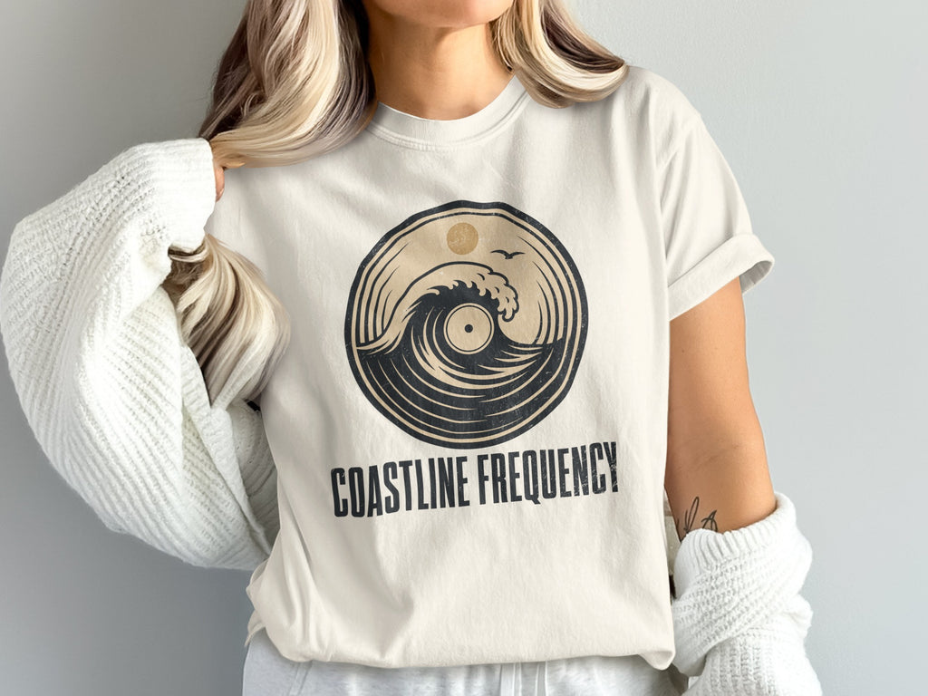 Cream t-shirt with circular wave and record graphic; "COASTLINE FREQUENCY" text.