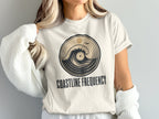 Cream t-shirt with circular wave and record graphic; "COASTLINE FREQUENCY" text.