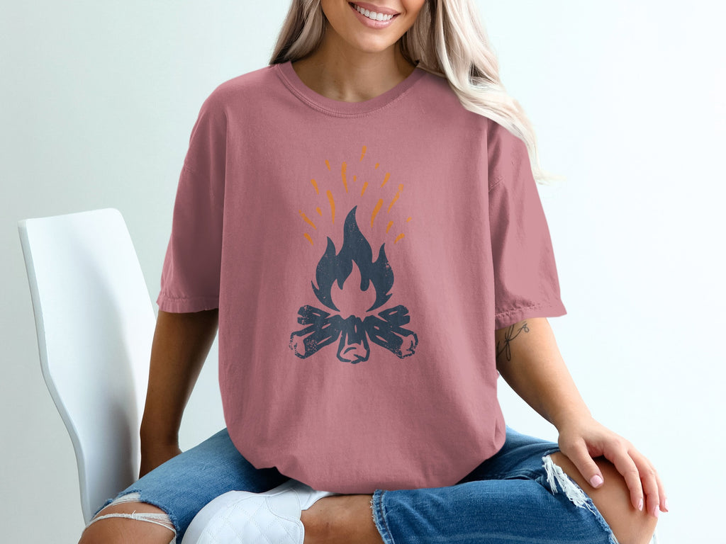 Pink t-shirt with campfire graphic and orange flames.
