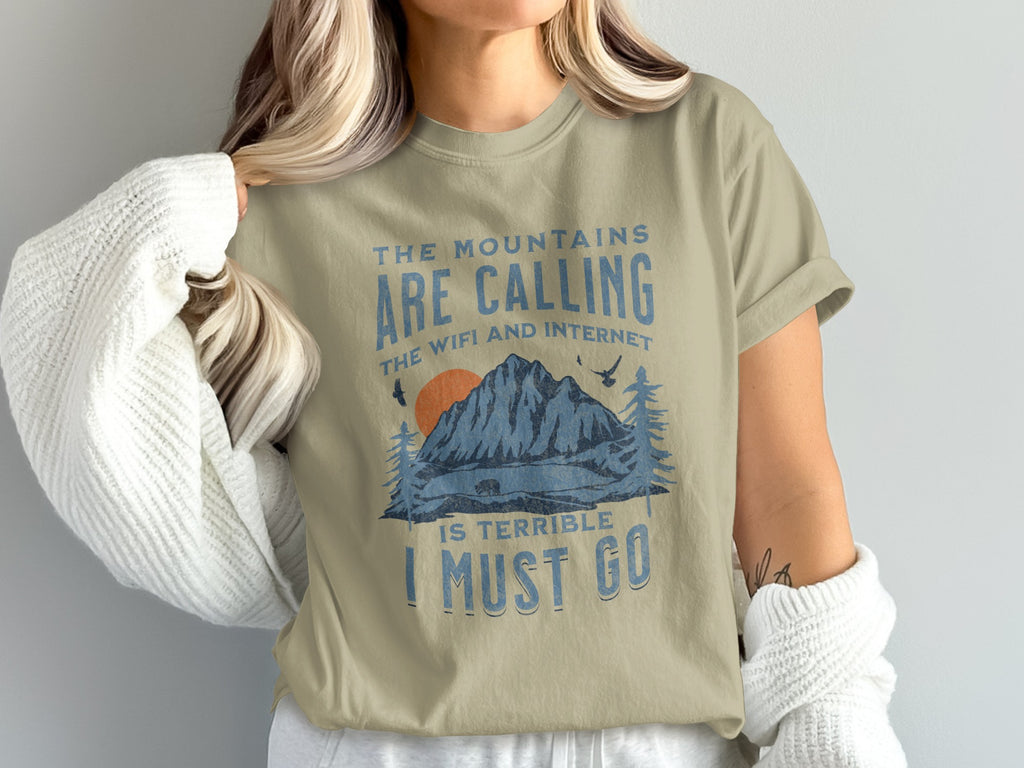 Light beige t-shirt with "The mountains are calling, the wifi and internet is terrible, I must go" text.