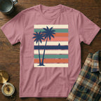Pink t-shirt with vintage striped sunset and palm trees graphic.
