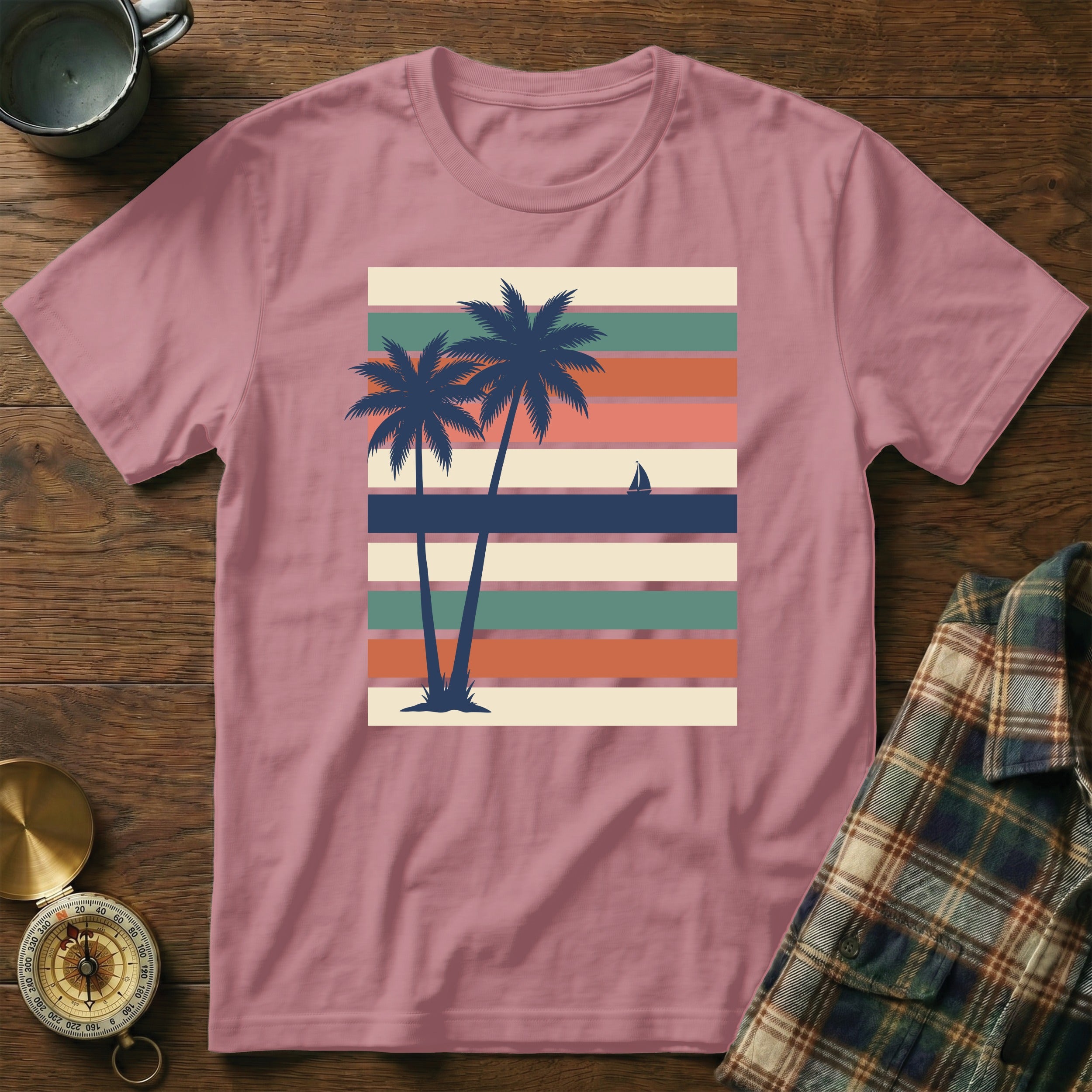 Pink t-shirt with vintage striped sunset and palm trees graphic.