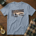 Light blue t-shirt with "ROUGHING IT." text and beach scene graphic.