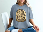 "Slow is the Whole Point" text with a turtle wearing sunglasses on a beach with a surfboard.