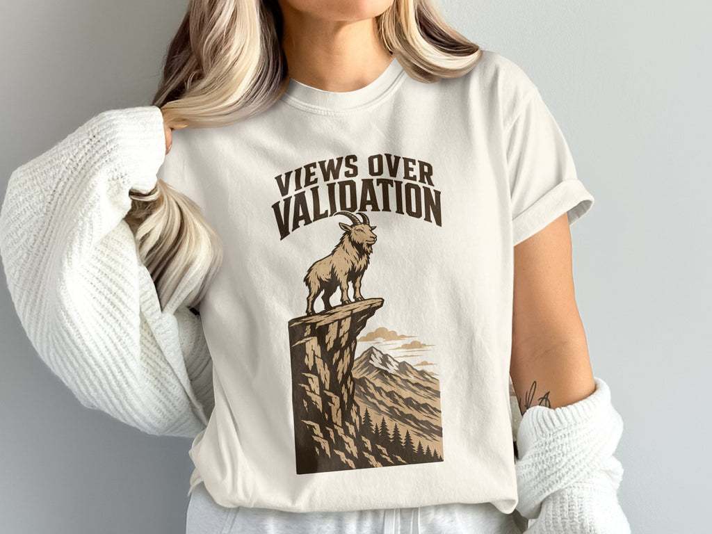 White t-shirt graphic with text "Views Over Validation" and a goat on a cliff.