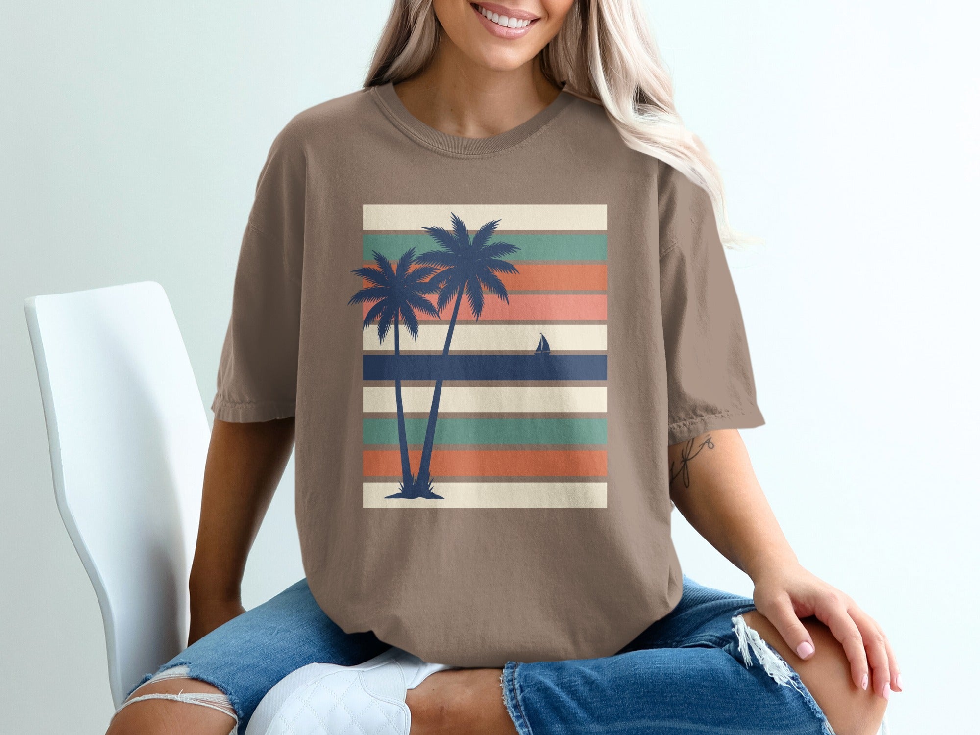 Brown t-shirt with a graphic of palm trees against a striped background.