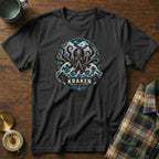 Black t-shirt with Kraken graphic featuring tentacles and waves, text "KRAKEN BEYOND THE DEPTHS".