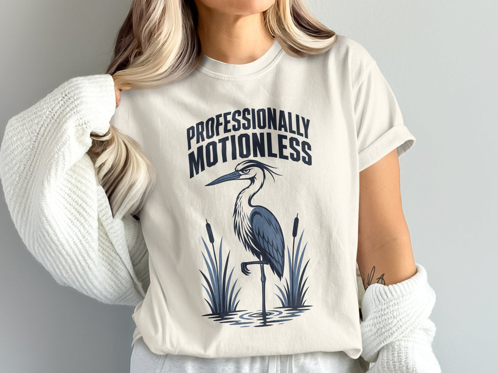 Cream t-shirt with "PROFESSIONALLY MOTIONLESS" and a heron graphic.
