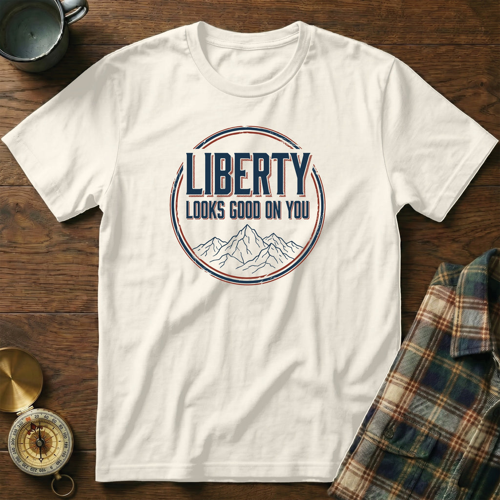 White t-shirt with "LIBERTY LOOKS GOOD ON YOU" text and mountain graphic.