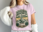 Pink t-shirt with "Raised on Mountain Air & AM Radio" graphic featuring mountains and van.