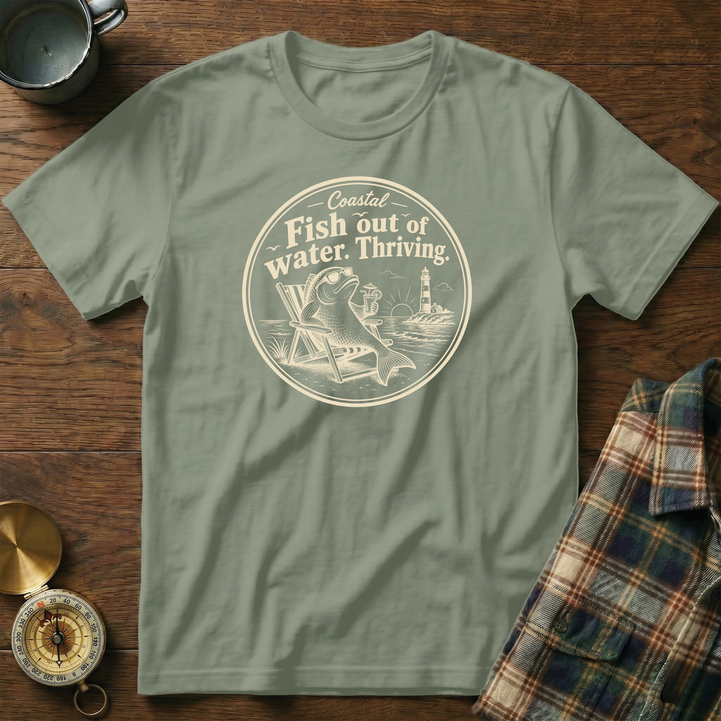 Sage green crewneck t-shirt featuring a circular graphic with a fish in sunglasses lounging in a beach chair.