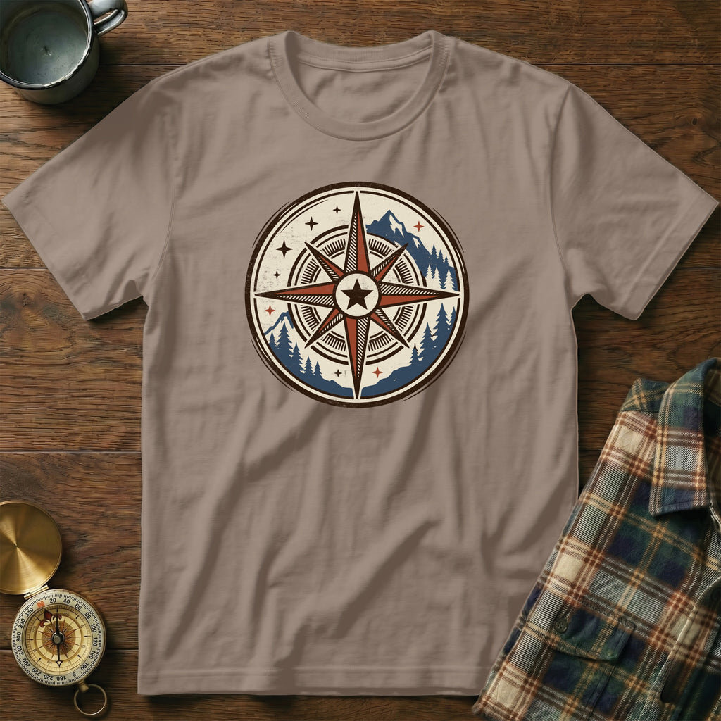 Light brown t-shirt with a circular compass design featuring mountains and trees.