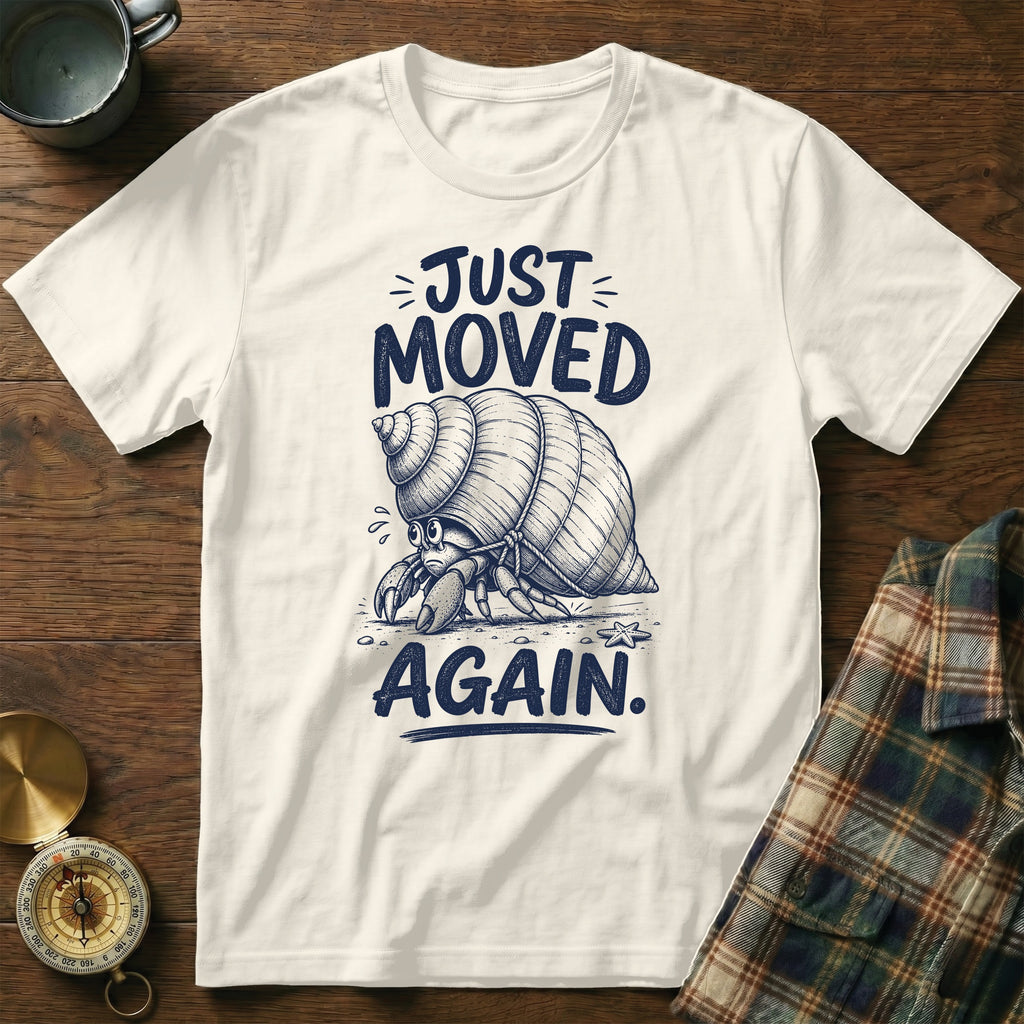 White t-shirt with a hermit crab illustration and text "JUST MOVED AGAIN."