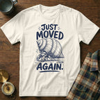 White t-shirt with a hermit crab illustration and text "JUST MOVED AGAIN."
