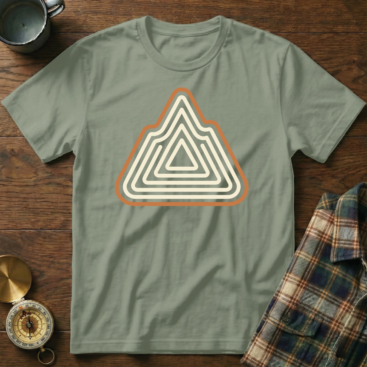 Green t-shirt with a concentric mountain graphic and compass.