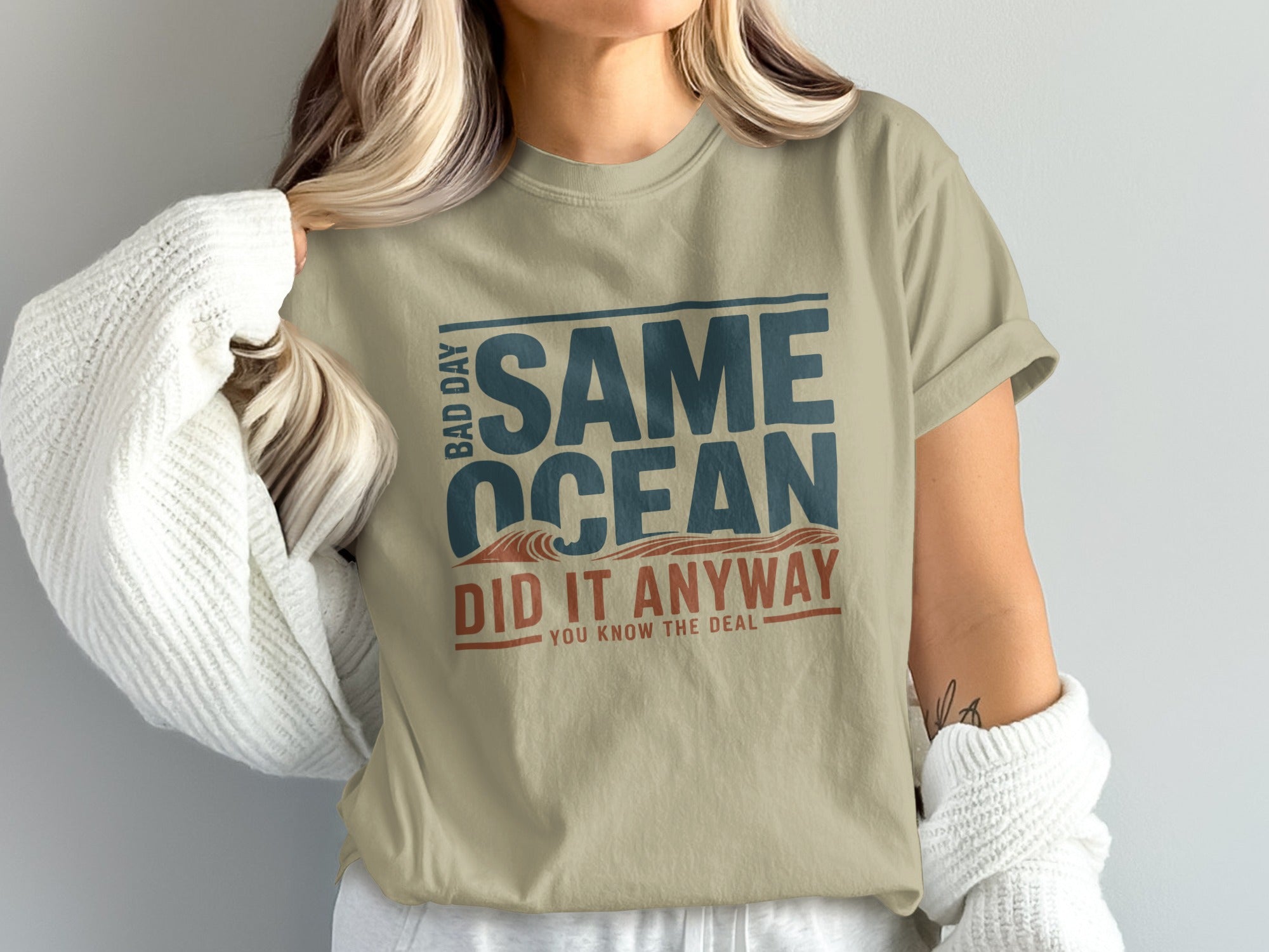 T-shirt with "Same Ocean Did It Anyway" text and ocean wave graphic.
