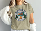 T-shirt graphic with cassette tape, campfire, and trees, reading "Retro Sounds & Outdoor Adventure Awaits".