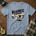 Light blue t-shirt with "Wilderness Expert" text and camping chair illustration.