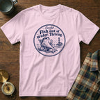 A light pink crewneck t-shirt featuring a circular blue graphic of a fish lounging in a beach chair with a drink.