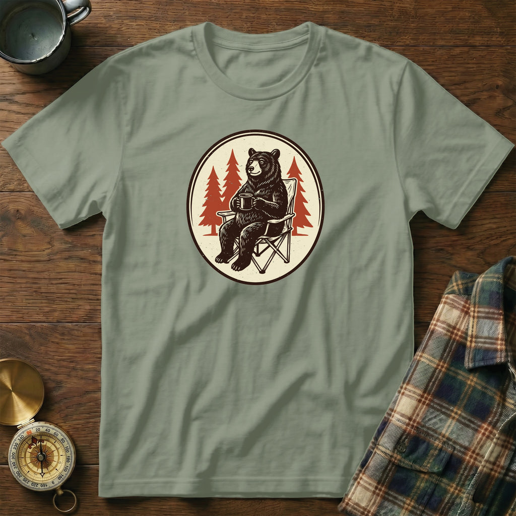 Green t-shirt with graphic of a bear sitting in a camping chair holding a mug.