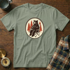 Green t-shirt with graphic of a bear sitting in a camping chair holding a mug.