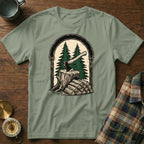 Green t-shirt with graphic of axe in wood stump, pine trees, and firewood.