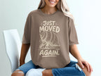 Brown t-shirt with "JUST MOVED AGAIN" text and hermit crab graphic.
