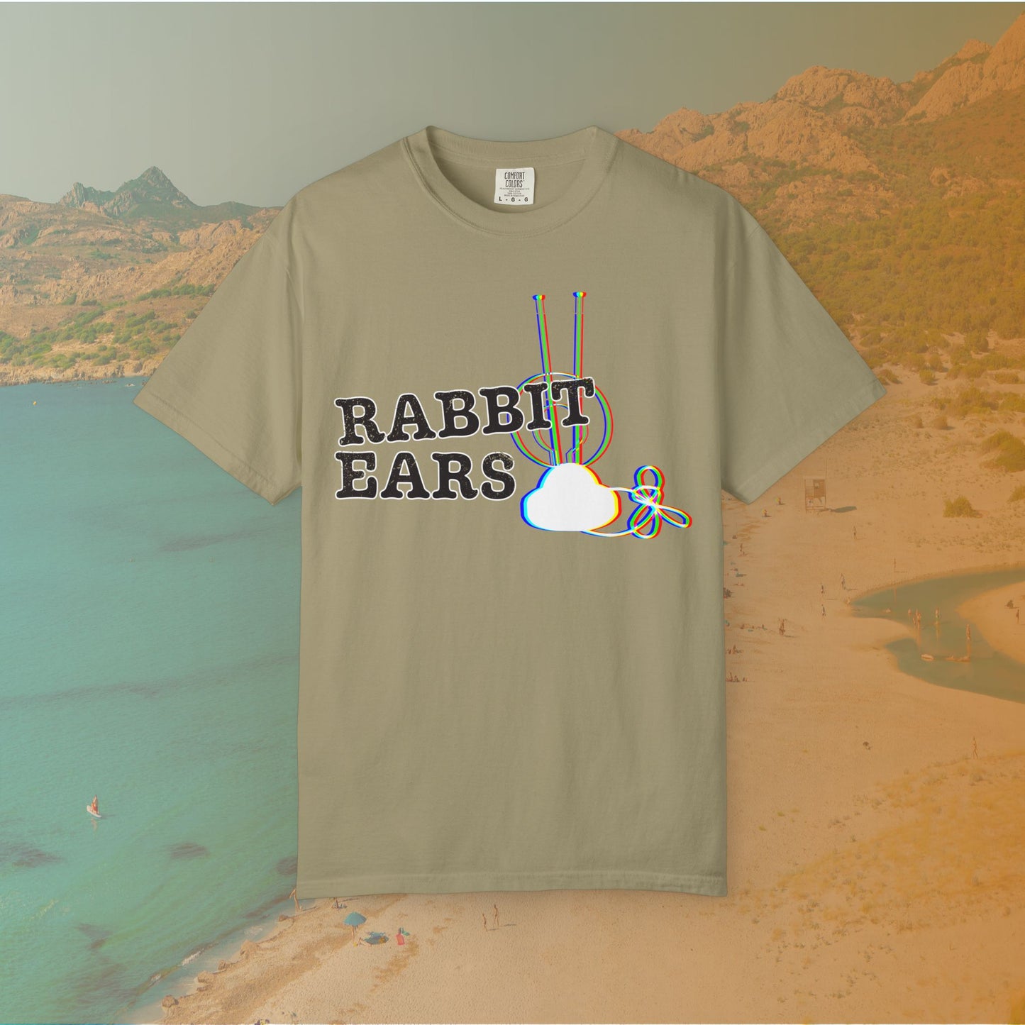 khaki t-shirt distressed EDM music festival text "RABBIT EARS" next to a graphic of a vintage TV antenna and cloud shape with a red, green, and blue (RGB) chromatic aberration/glitch effect, with an RGB shift design