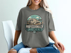 T-shirt graphic with seal on dock, lighthouse, and text "Professionally Unbothered."