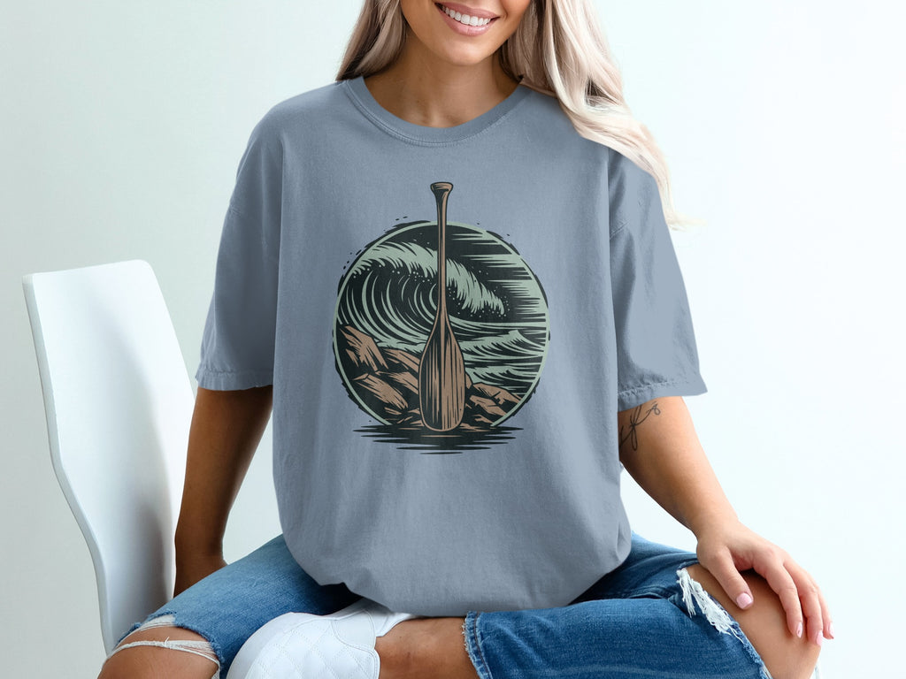 T-shirt with a wooden oar and crashing wave graphic.