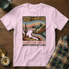Pink t-shirt with desert mountains graphic and "Adventure Awaits Southwest USA" text.