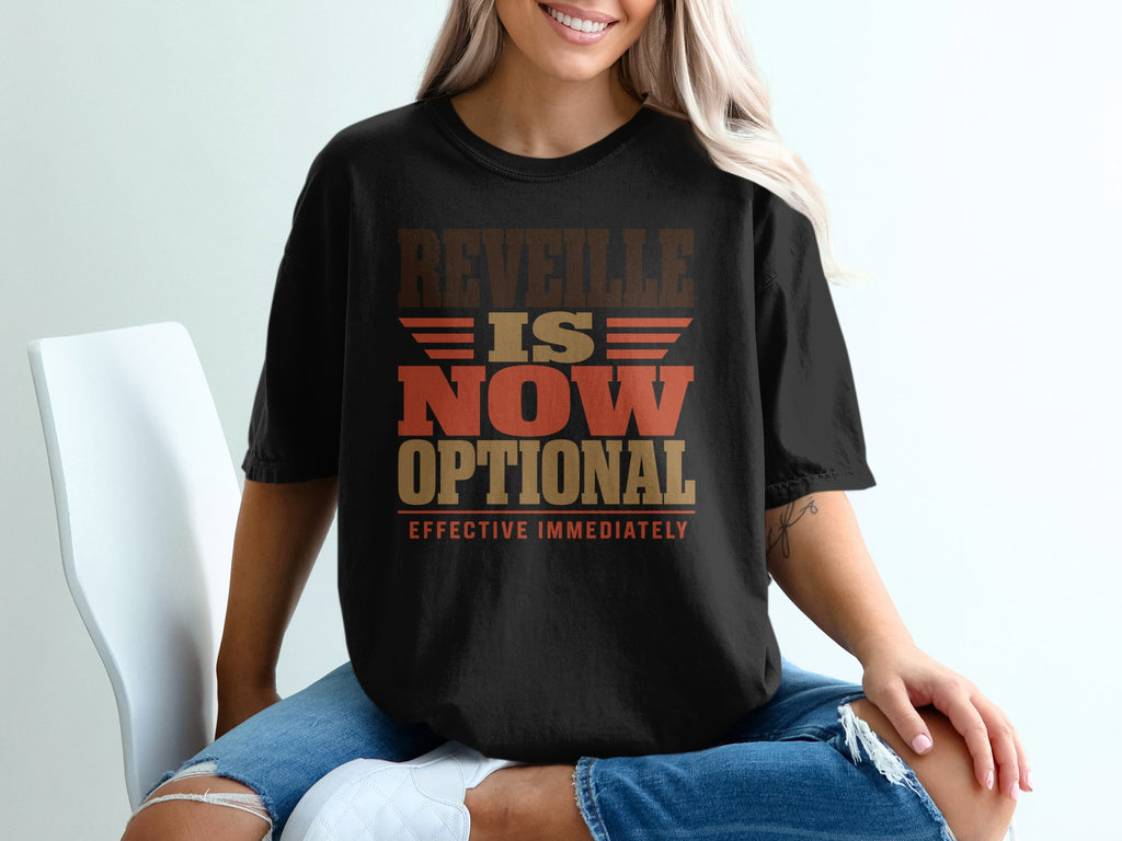 A blonde woman wearing a black t-shirt printed with the words Reveille is Now Optional, Effective Immediately.