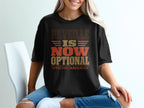 A blonde woman wearing a black t-shirt printed with the words Reveille is Now Optional, Effective Immediately.