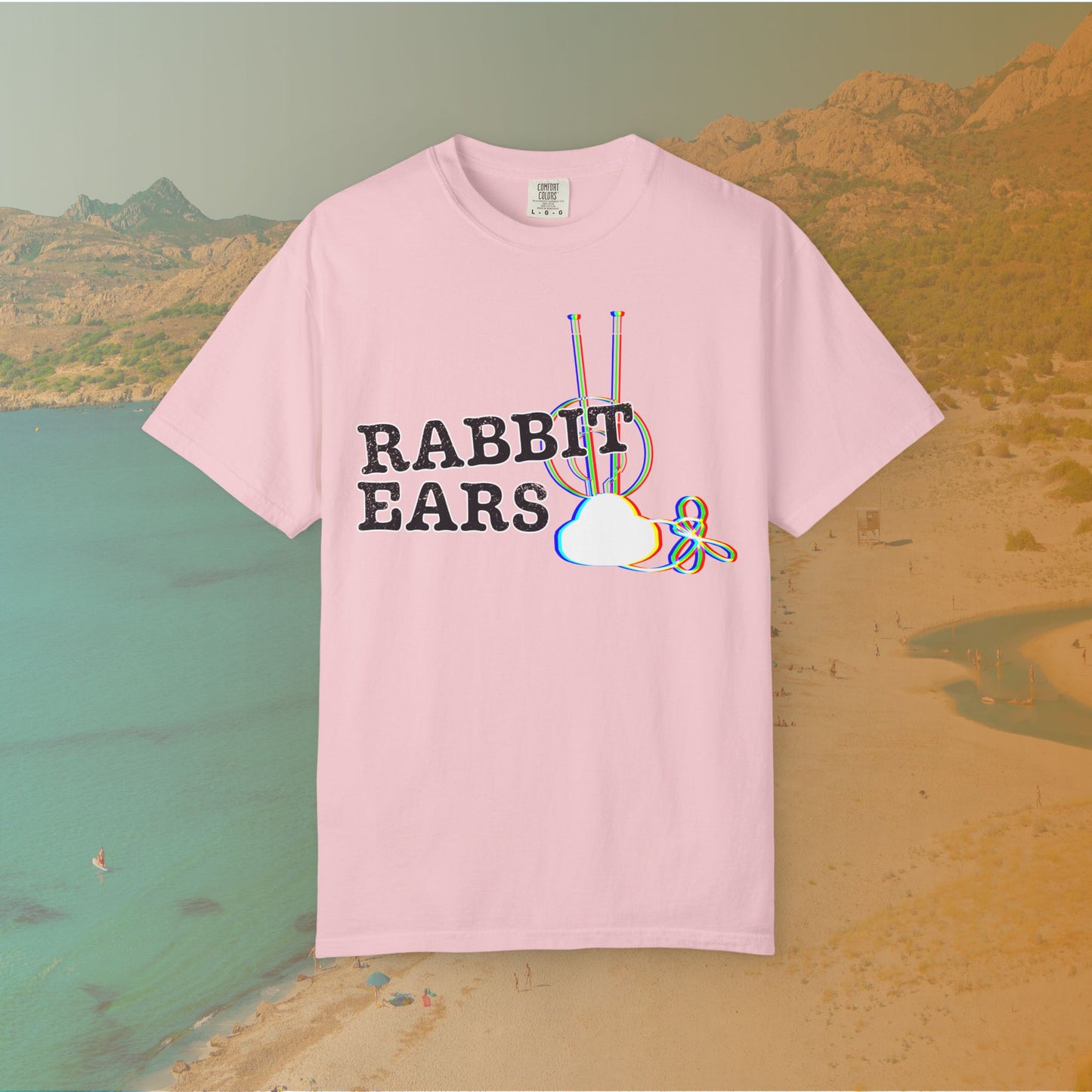 pink t-shirt distressed EDM music festival text "RABBIT EARS" next to a graphic of a vintage TV antenna and cloud shape with a red, green, and blue (RGB) chromatic aberration/glitch effect, with an RGB shift design