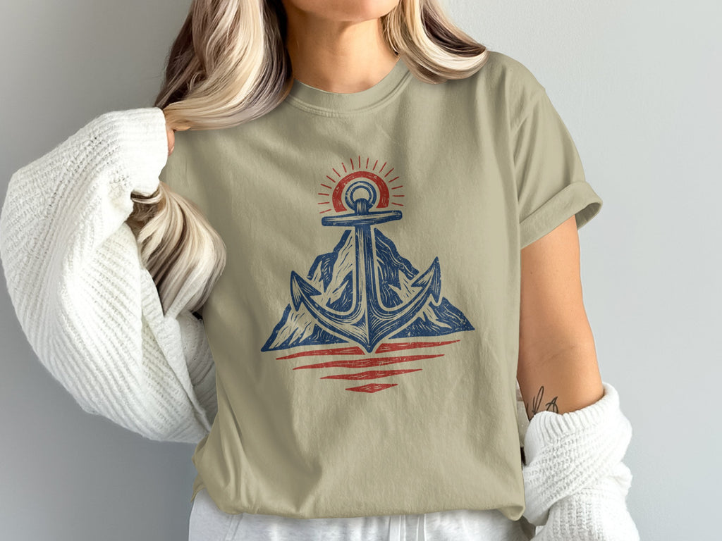 Anchor with sun over mountains and water graphic on tan t-shirt.