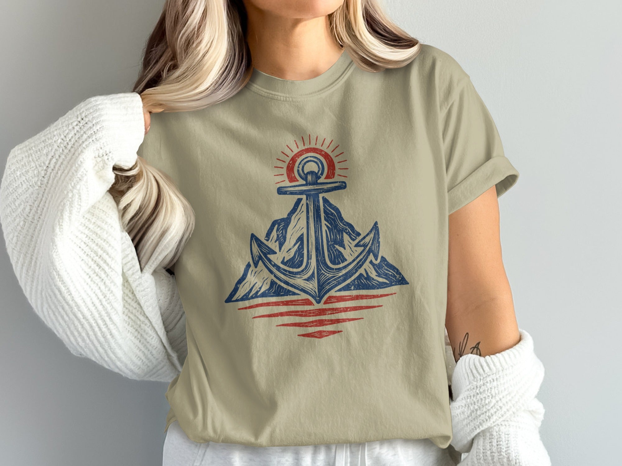 Anchor with sun over mountains and water graphic on tan t-shirt.
