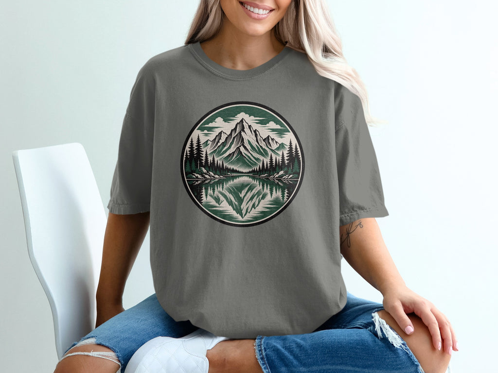 T-shirt with circular mountain and forest reflection graphic.