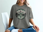 T-shirt with circular mountain and forest reflection graphic.