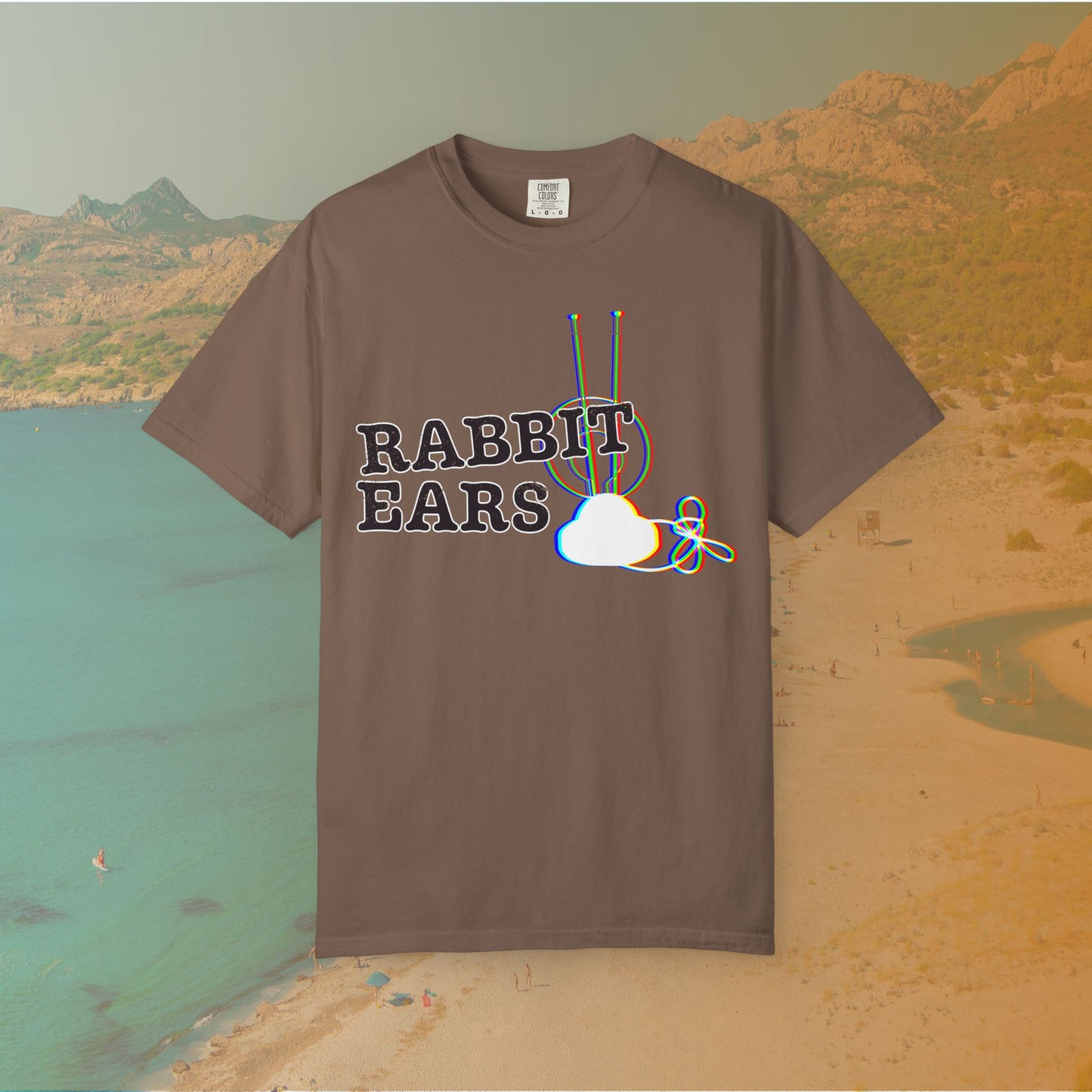 brown t-shirt distressed EDM music festival text "RABBIT EARS" next to a graphic of a vintage TV antenna and cloud shape with a red, green, and blue (RGB) chromatic aberration/glitch effect, with an RGB shift design