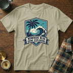 T-shirt with a shield design featuring a palm tree, wave, and the text "NOWHERE NEAR DONE EXPLORING".