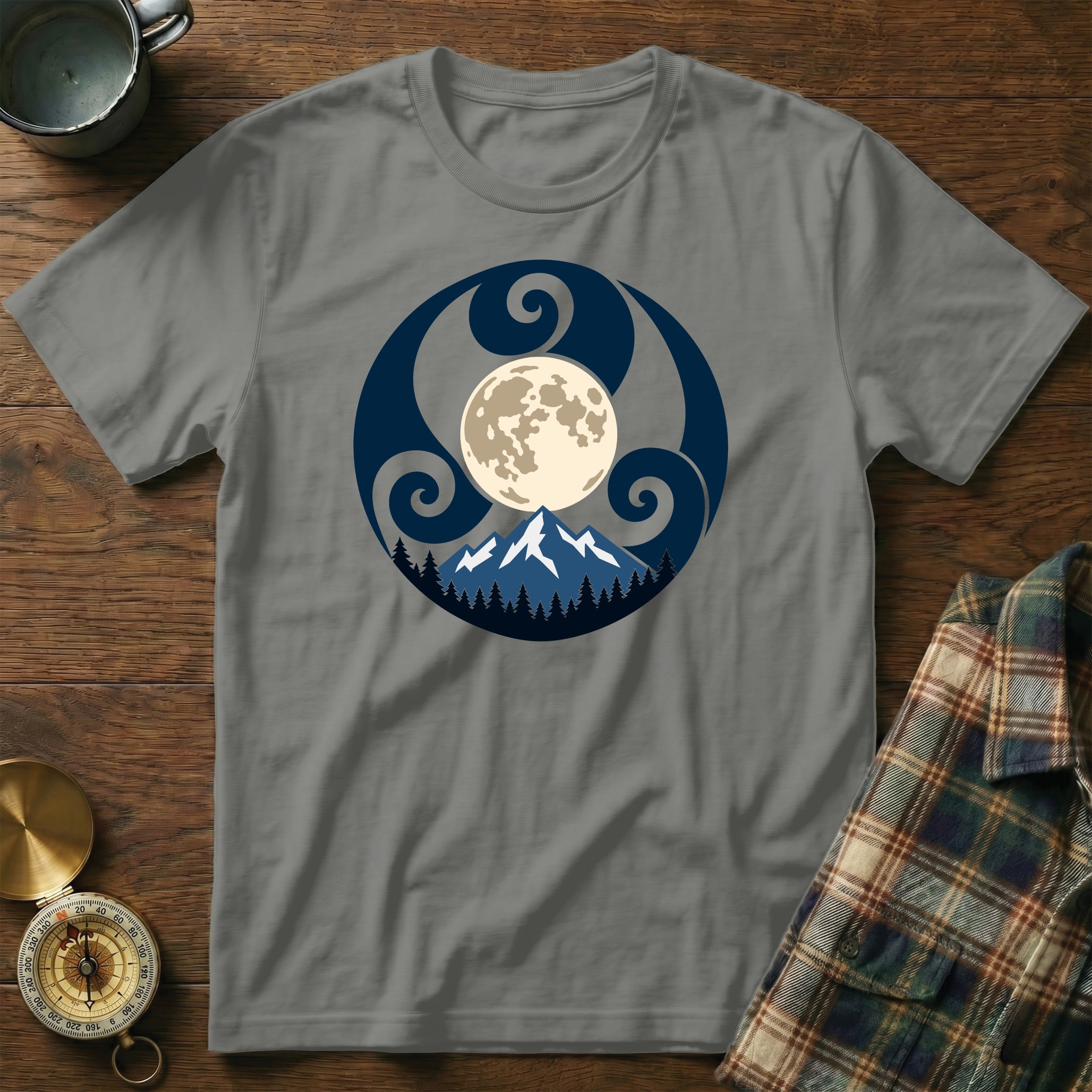 Grey t-shirt with a circular design of the moon, mountains, trees, and Celtic knot.