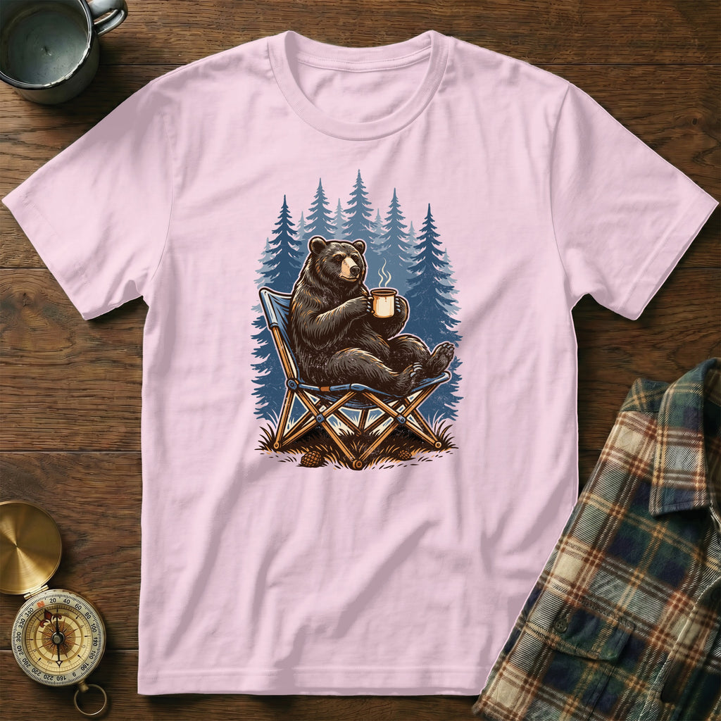 Pink t-shirt with a graphic of a bear drinking coffee in a forest.