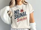 Cream t-shirt with "NO SIGNAL STILL GOT SUNBURNED" text and red sun graphic.